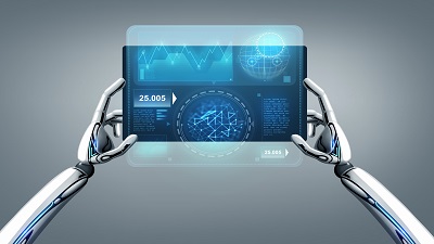 Robotic hands holding a transparent digital tablet that displays futuristic data visualizations such as graphs, charts, and numerical metrics, set against a gradient gray background.