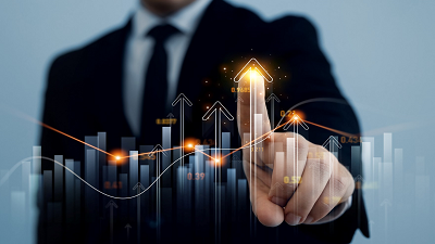 A person in a suit pointing at a glowing arrow within a digital graph featuring multiple upward arrows and bar charts, symbolizing growth and progress.